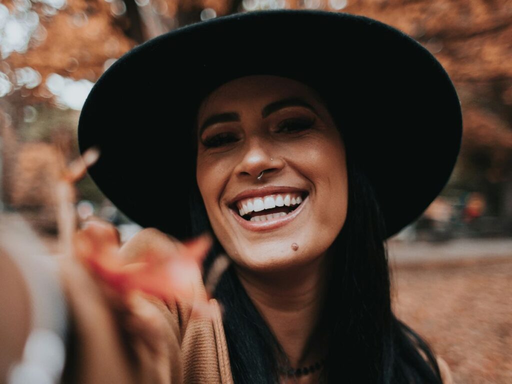 donna sorridente in mezzo al bosco in autunno