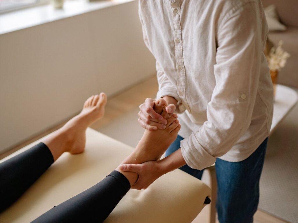 Operatrice pratica la riflessologia plantare contro lo stress
