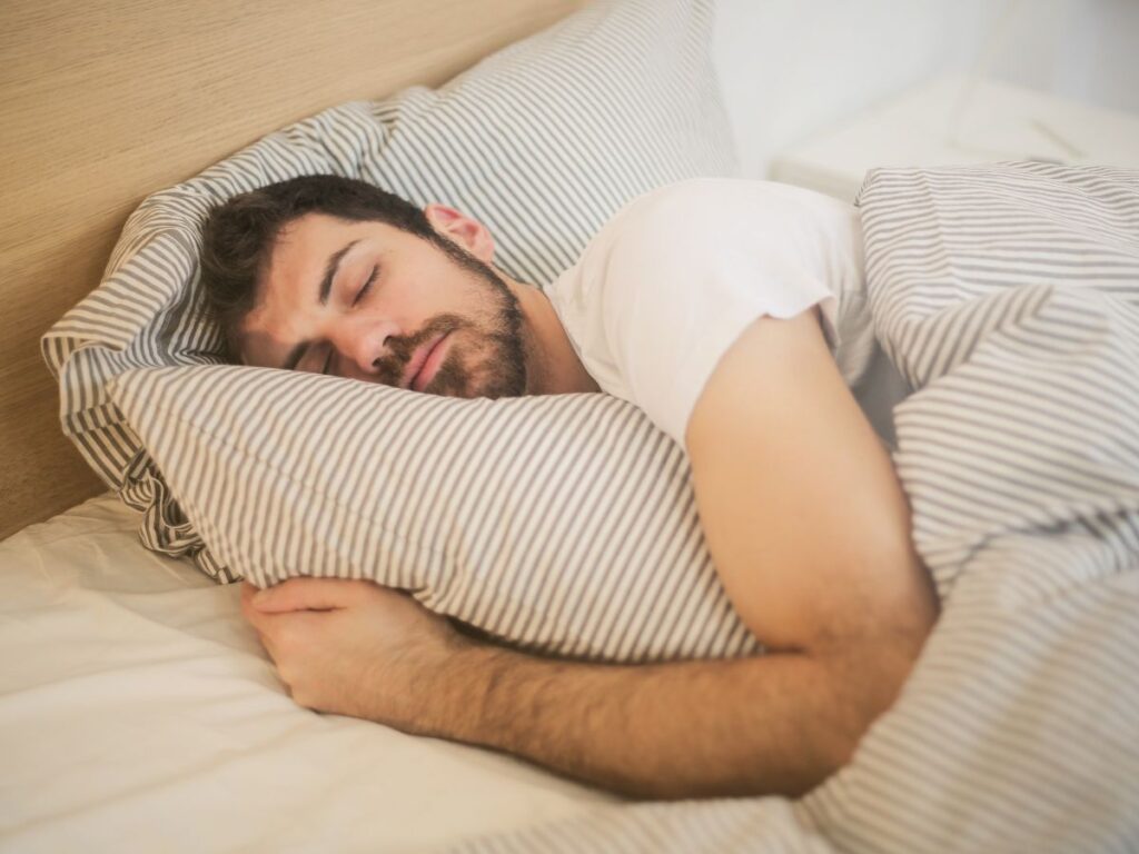 uomo dorme con due cuscini in modo scomposto