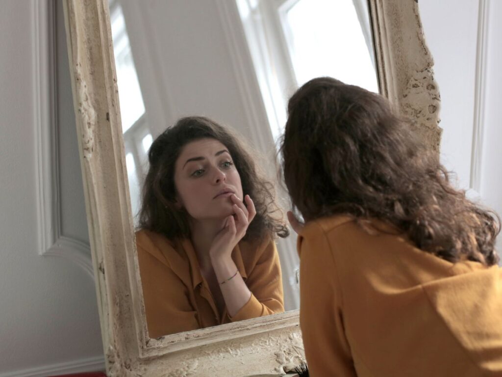 donna allo specchio con viso gonfio