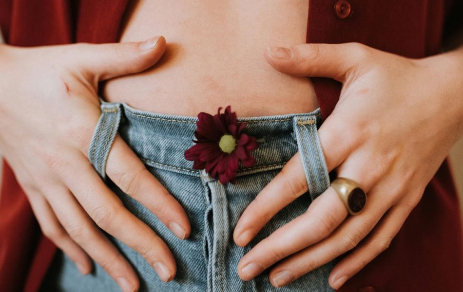 donna tiene tra le mani la pancia gonfia dopo avere mangiato